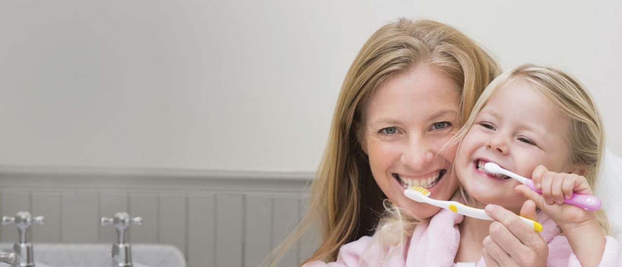 mother and daughter brushing teeth
